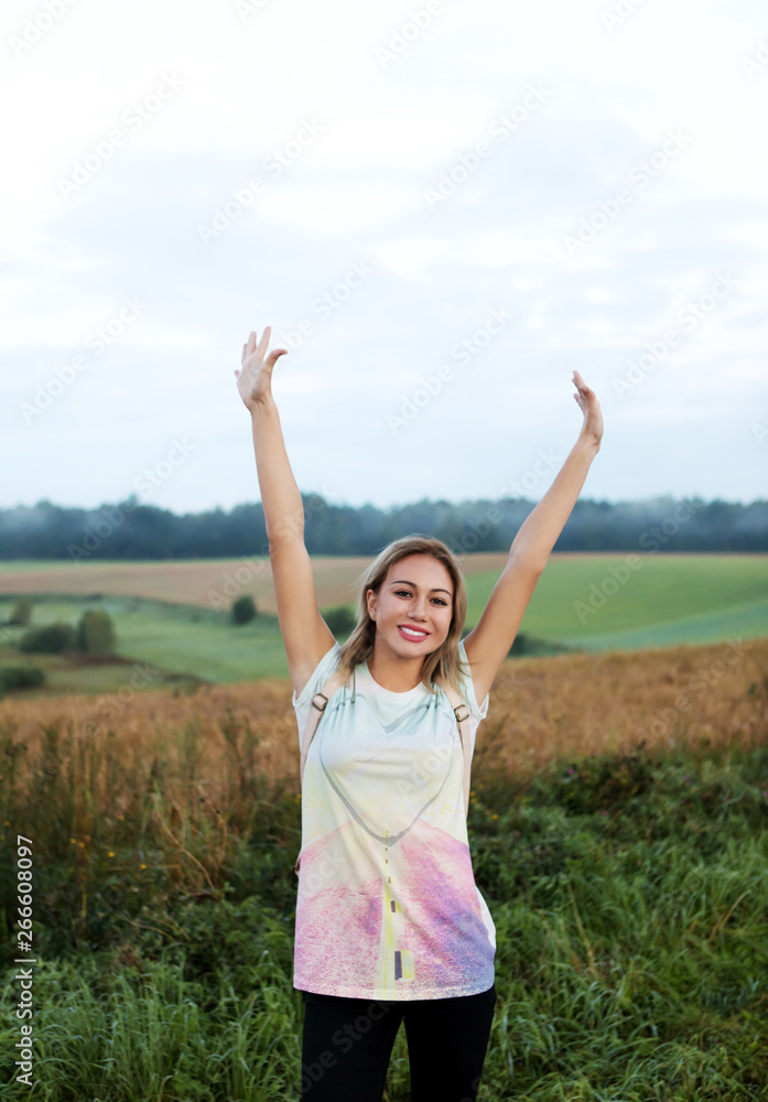 Young tourist woman walking on a greenery hill trail with a backpack. Young tourist woman walking on a greenery hill trail with a backpack.