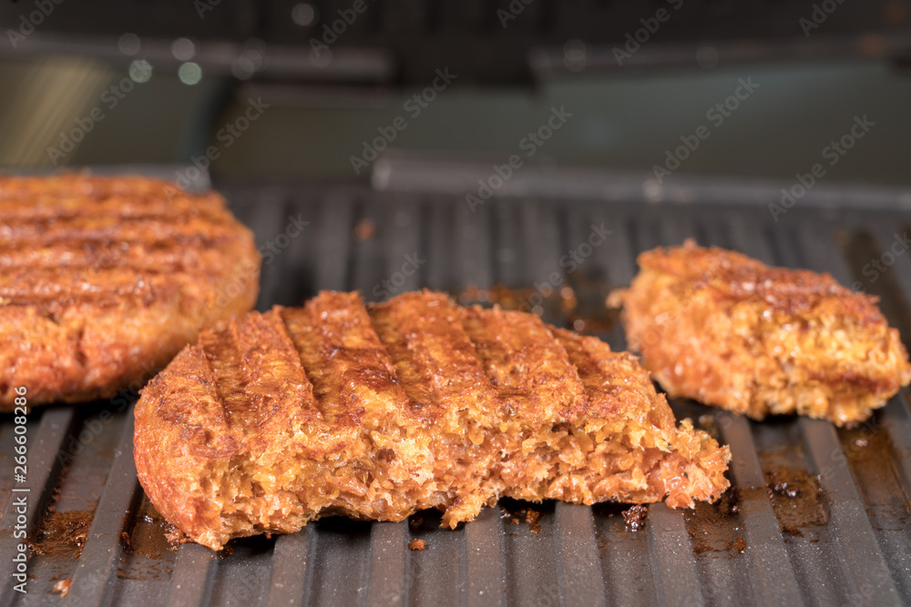 Close shot of the meat like plant-based patties for vegetarian beef burgers being grilled on hot griddle