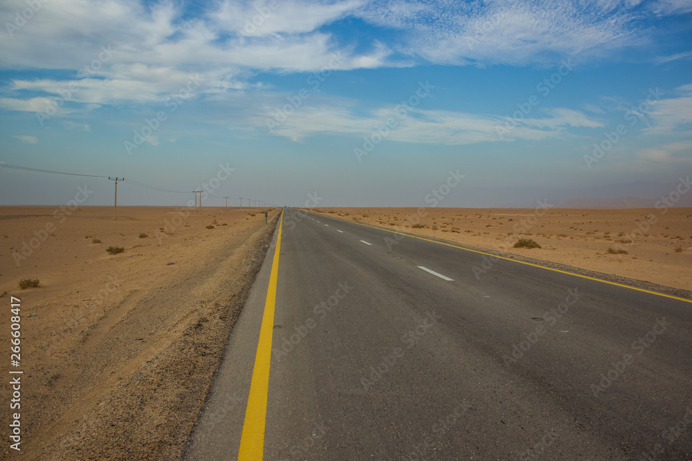 driving transportation object country side empty car road through big desert sand valley outdoor scenery landscape with blue sky with background horizontal line with blue sky and  white clouds 