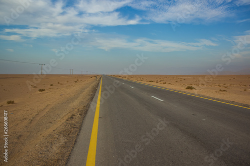 driving transportation object country side empty car road through big desert sand valley outdoor scenery landscape with blue sky with background horizontal line with blue sky and white clouds 