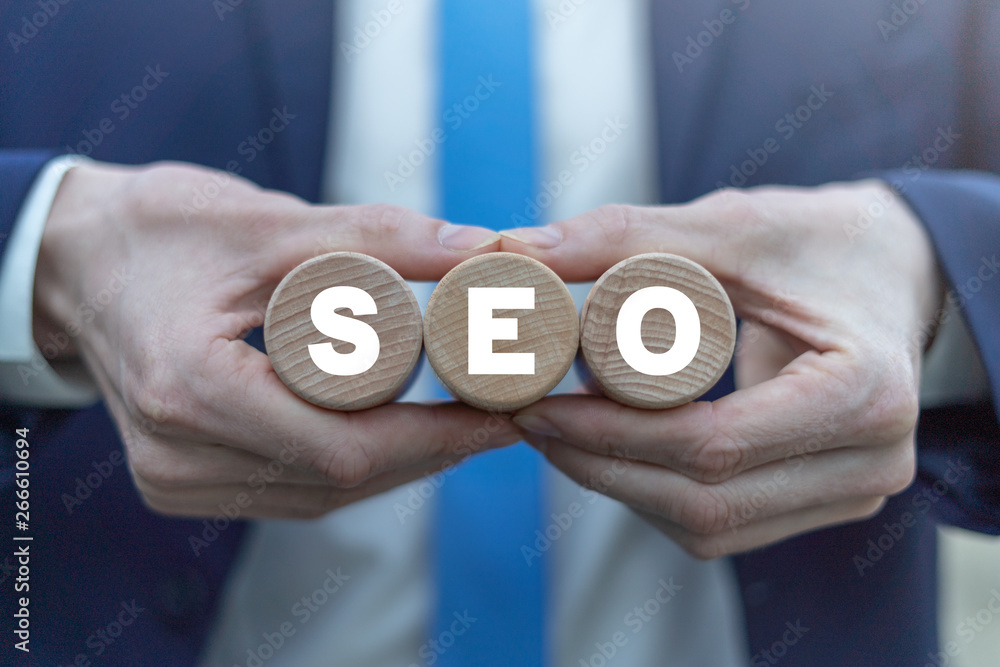 SEO concept on a wooden cylinders in a businessman hands. Search Engine Optimization Web Technology. SEO concept on a wooden cylinders in a businessman hands. Search Engine Optimization Web Technology.
