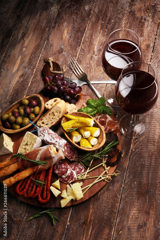 antipasto various appetizer. Cutting board with prosciutto, salami, cheese, bread and olives on dark wooden background antipasto various appetizer. Cutting board with prosciutto, salami, cheese, bread and olives on dark wooden background