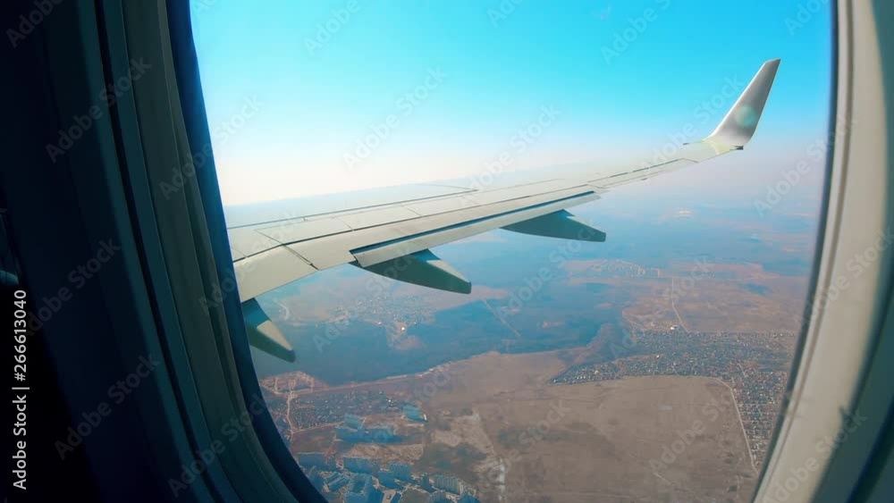 Metal airplane wing moves while a plane flies in the sky. Metal airplane wing moves while a plane flies in the sky.