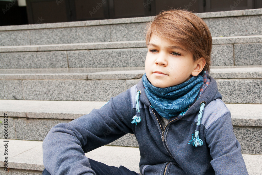 Portrait of a serious teenager outdoors on the steps of a building Portrait of a serious teenager outdoors on the steps of a building