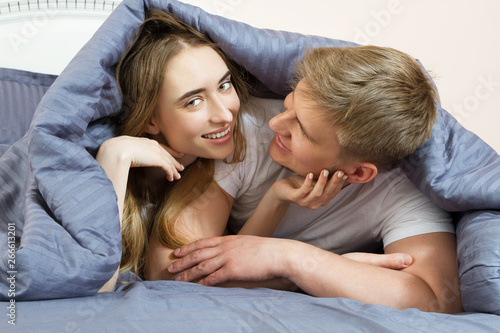 Happy couple is lying in bed together