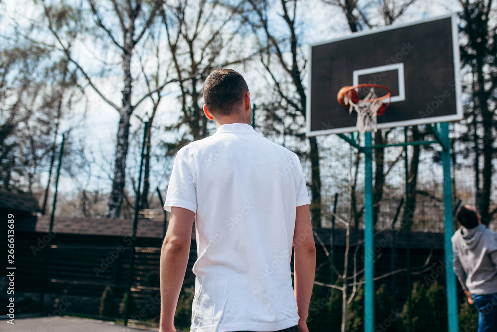 Young man wearing white blank polo, playing streetball Young man wearing white blank polo, playing streetball