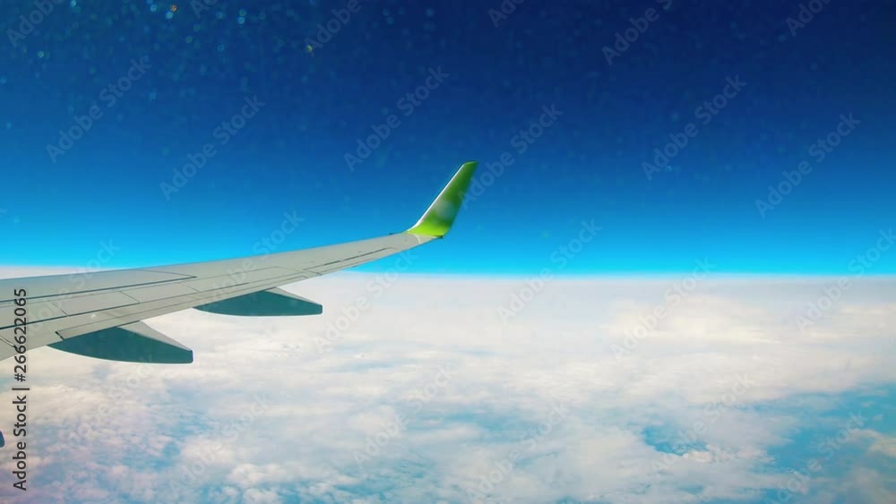 Metal wing moves while a plane flies high in the sky. Metal wing moves while a plane flies high in the sky.