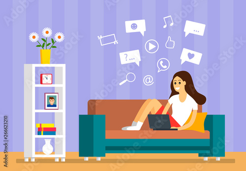 A beautiful young girl is sitting on the sofa with a laptop in a room for searching information on the Internet. The concept of modern man and the sensations of learning online.