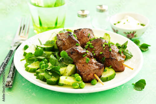 Beef kebab with cucumber and green pea salad. Healthy food.