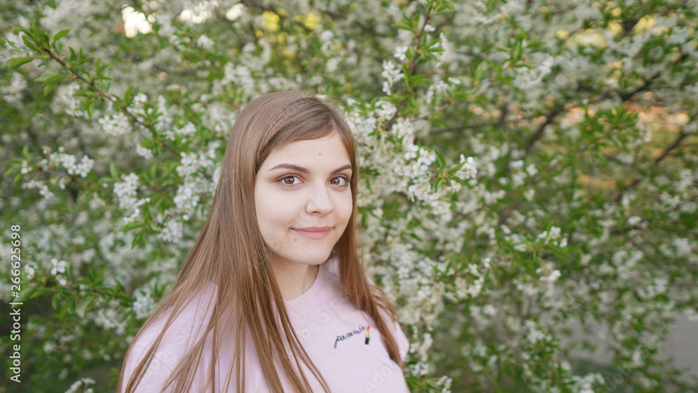 Young beautiful woman smells blooming sakura. Spring woman in cherry flower bloom. Happy mothers day or happy woman day. Outdoor lifestyle. Freedom concept Young beautiful woman smells blooming sakura. Spring woman in cherry flower bloom. Happy mothers day or happy woman day. Outdoor lifestyle. Freedom concept