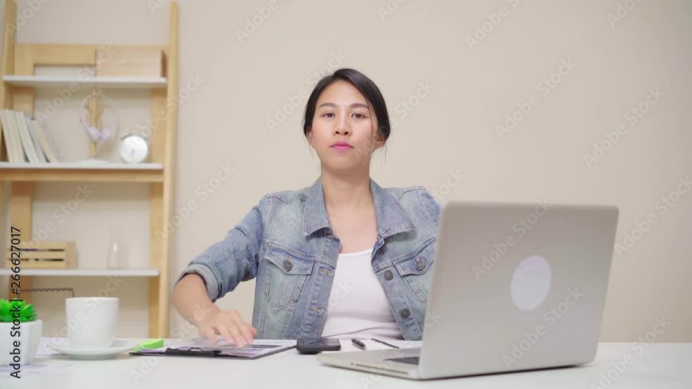 Young asian woman working using laptop on desk in living room at home. Asia business woman success celebration feeling happy dancing at home office. Enjoying time at home concept. Young asian woman working using laptop on desk in living room at home. Asia business woman success celebration feeling happy dancing at home office. Enjoying time at home concept.