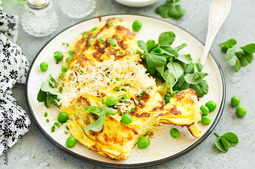 Breakfast. Frittata Italian omelet with green peas and salad.