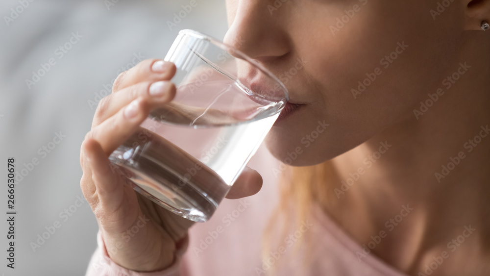 Close up image woman holds glass drinking still water Close up image woman holds glass drinking still water