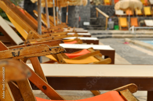 Wooden old sun beds on the beach by the pool photo