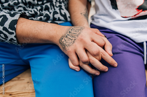 Gay couple holding each other's hands close up