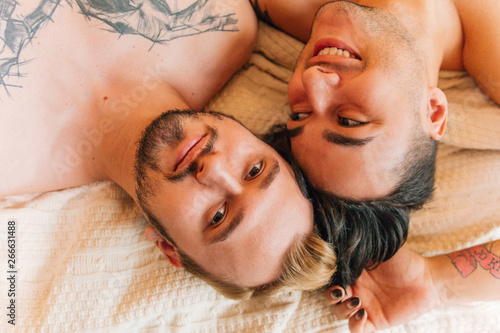 Gay couple lying in bed close up top view