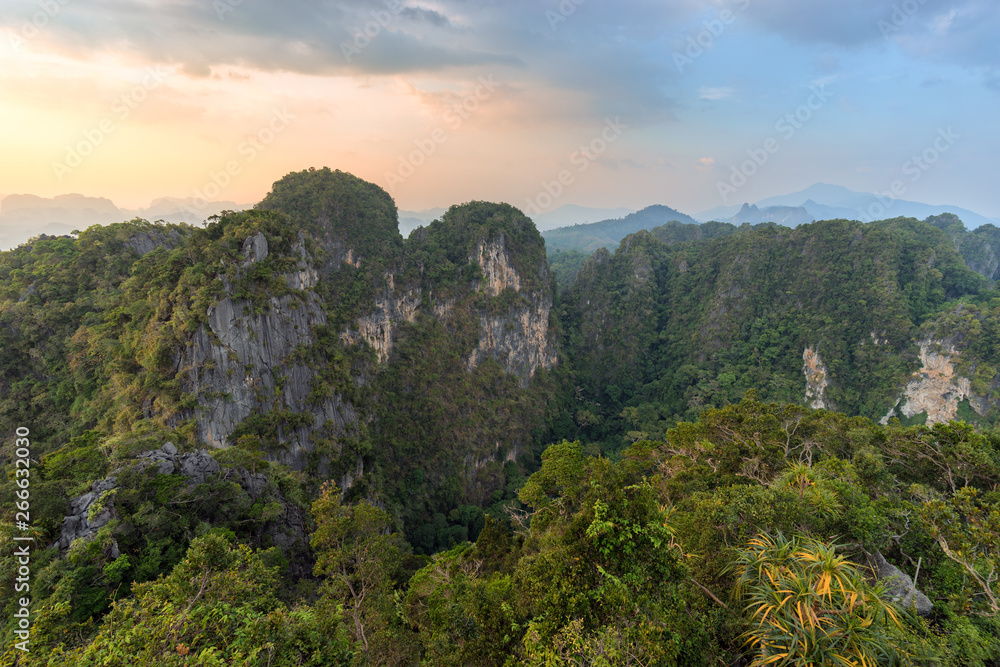 Landscape of mountains covered by tropical greenery and trees in asian nature at sunset