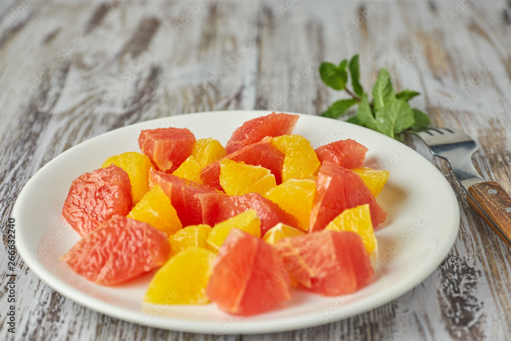Orange-grapefruit citrus salad on a shabby wooden table close-up. summer vitamin salad. healthy food. dietary salad. Orange-grapefruit citrus salad on a shabby wooden table close-up. summer vitamin salad. healthy food. dietary salad.