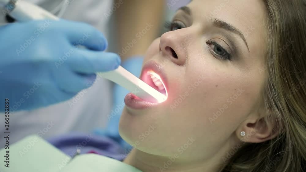 Pretty woman's teeth examining in dental clinic Pretty woman's teeth examining in dental clinic