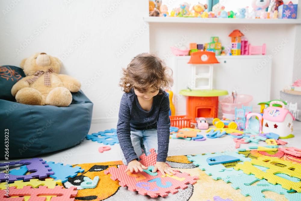 Fototapeta premium Little girl child playing with numbers puzzle