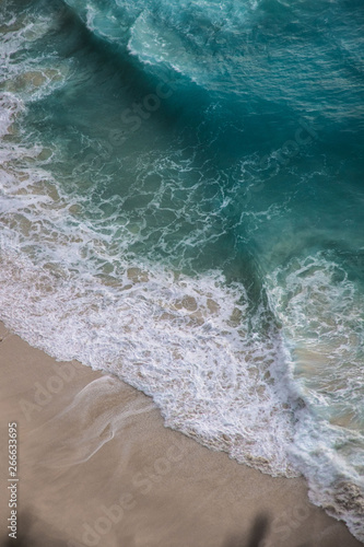 Mer vague bleu sur plage de sable fin rosé