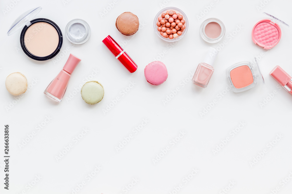 decorative cosmetics for make-up with macaroon cookies on white tabletop background space for text decorative cosmetics for make-up with macaroon cookies on white tabletop background space for text