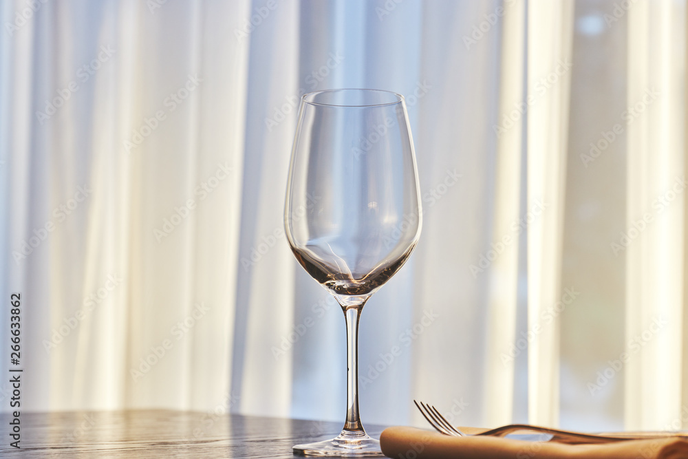 empty wine glass on the table in the restaurant on the background of the window in sunny weather. copy space. empty wine glass on the table in the restaurant on the background of the window in sunny weather. copy space.