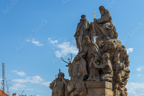 Outdoor sunny view statues of John of Matha, Felix of Valois and Saint Ivan stand on pedestal and balustrade of Charles Bridge. 