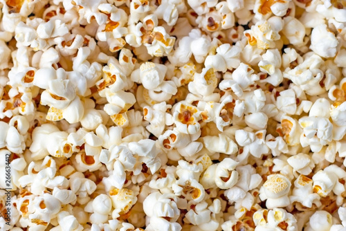 White and yellow fresh salted popcorn texture background. Close up top view food pattern photography