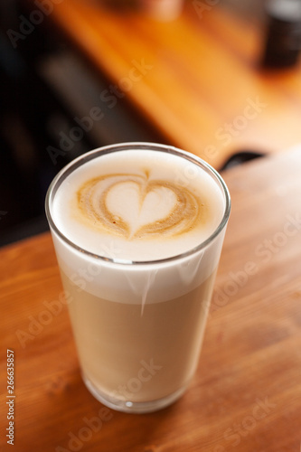 Latte in a glass with latte art on a milk froth