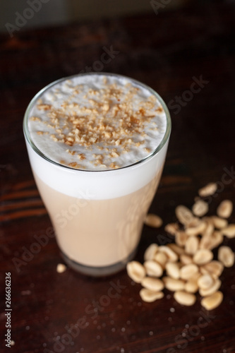 Frothy milk coffee decorated and served with peanuts
