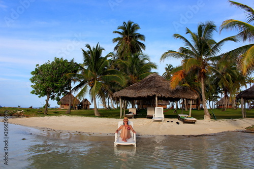 Young beautiful woman enjoying her time and resting in teh private beach of Yandup Island lodge, kuna indians territory, San Blas, Panama. photo