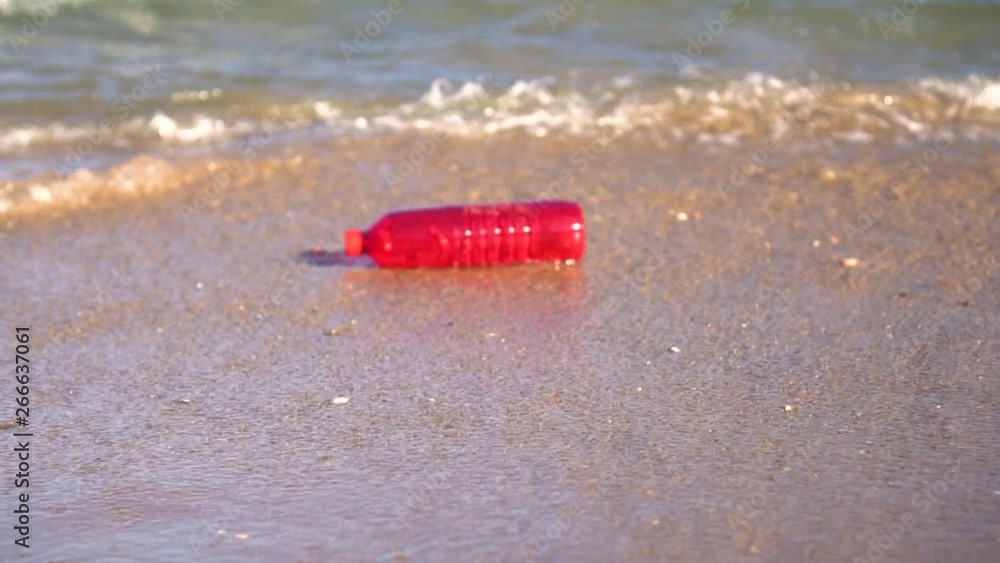 120fps: Red plastic bottle drift in water. Waste getting thrown on the beach by the waves. Sea Ocean pollution concept. 120fps: Red plastic bottle drift in water. Waste getting thrown on the beach by the waves. Sea Ocean pollution concept.