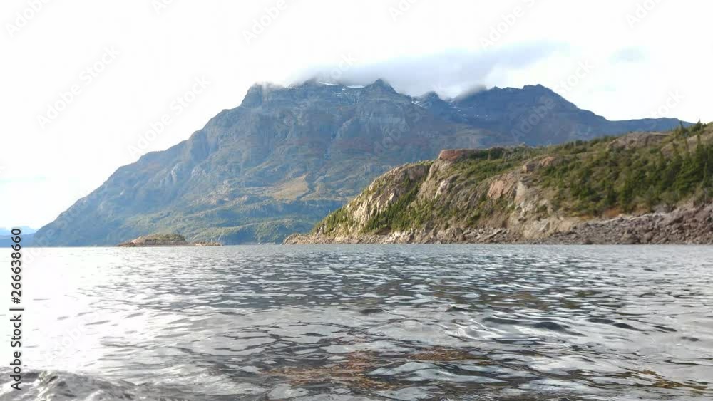 Scene view of a waves lake against andes mountains with clouds moving fast on the peaks. Scene view of a waves lake against andes mountains with clouds moving fast on the peaks.
