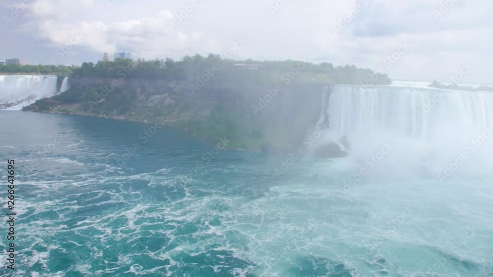 NIAGARA FALLS, ONTARIO, CANADA. Niagara Falls Hornblower Tour Boat under Horseshoe Waterfall Rainbow. Close-up shot of dangerous fast river rapids. NIAGARA FALLS, ONTARIO, CANADA. Niagara Falls Hornblower Tour Boat under Horseshoe Waterfall Rainbow. Close-up shot of dangerous fast river rapids.