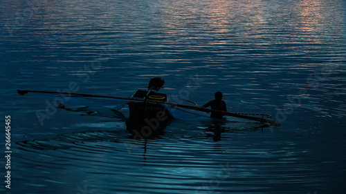 Silhouette of fishermen catching fish in the sea at sunset photo