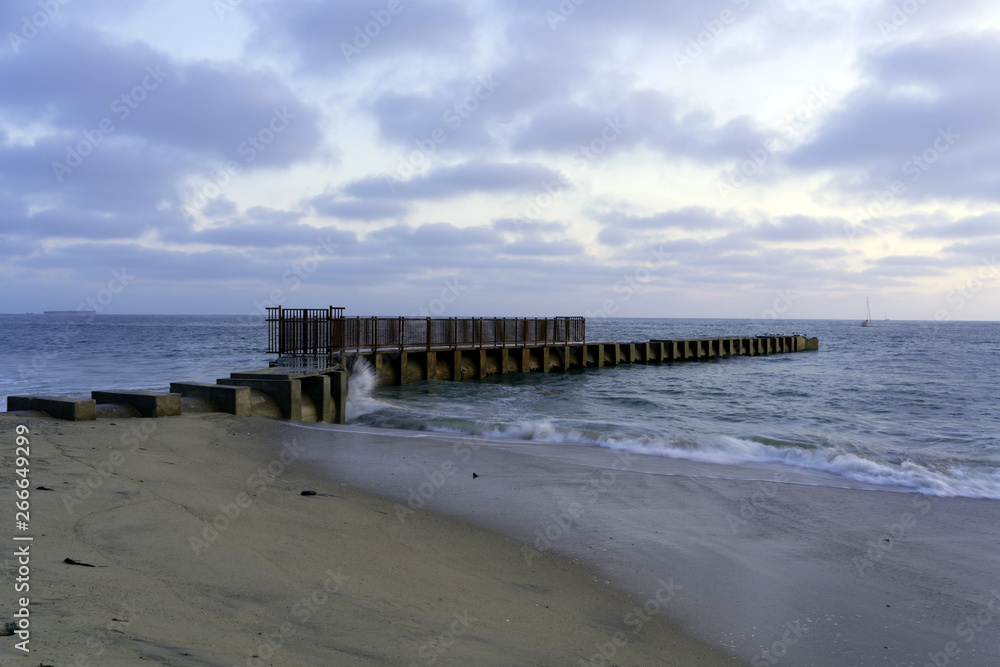 Old piers with waves breaking at the beach