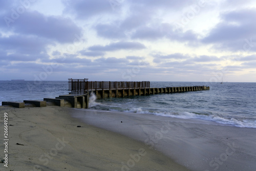 Fototapeta Naklejka Na Ścianę i Meble -  Old piers with waves breaking at the beach