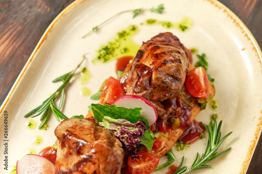 Grilled meat on pita bread on a bright oval plate. Dark wooden background. Restaurant menu Grilled meat on pita bread on a bright oval plate. Dark wooden background. Restaurant menu