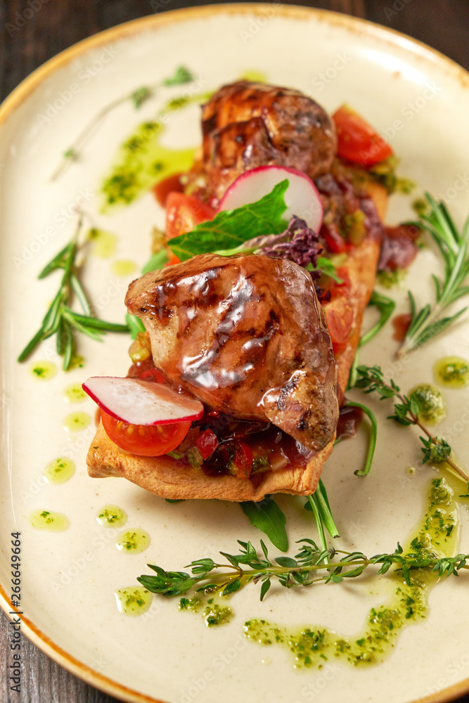 Grilled meat on pita bread on a bright oval plate. Dark wooden background. Restaurant menu Grilled meat on pita bread on a bright oval plate. Dark wooden background. Restaurant menu