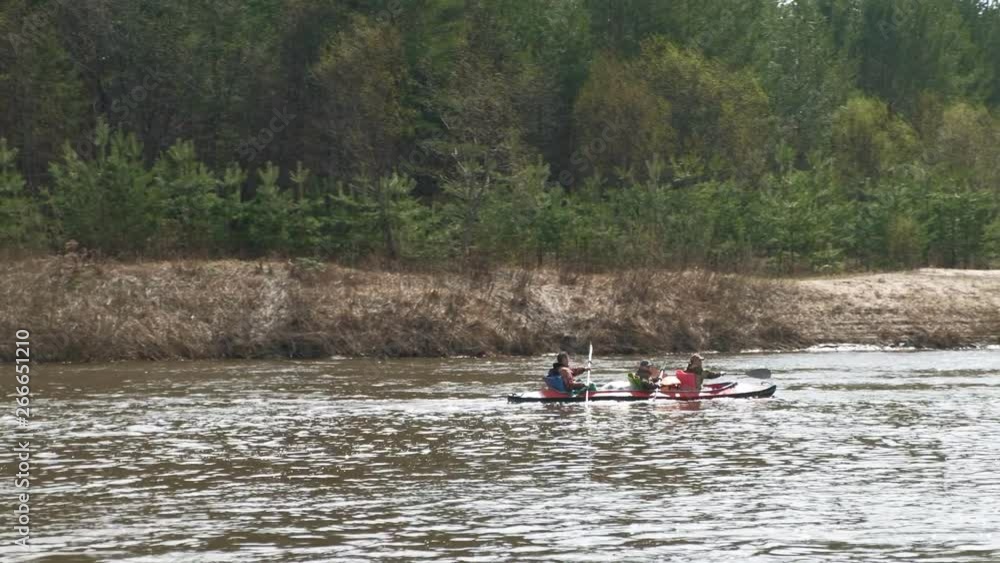 People paddle along the river in cloudy weather. People paddle along the river in cloudy weather.