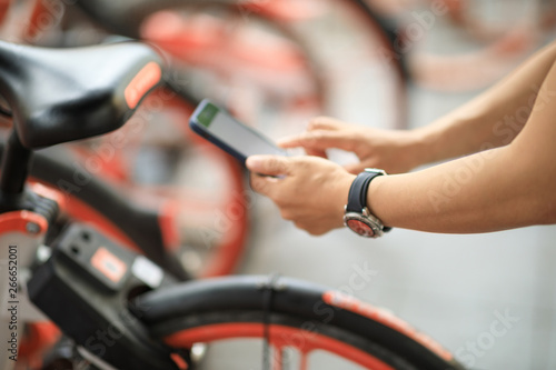 Hands using smartphone scanning the QR code of shared bike in city © lzf