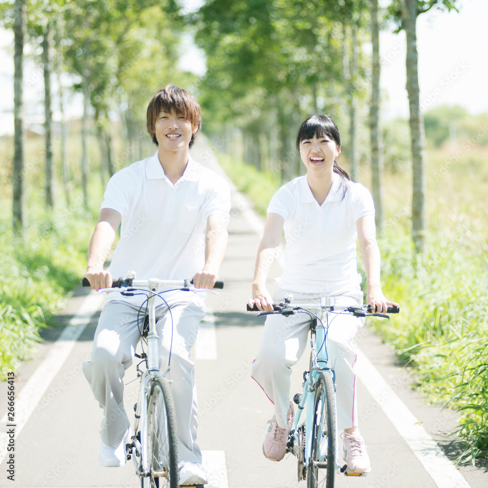 Obraz premium 一本道でサイクリングをするカップル