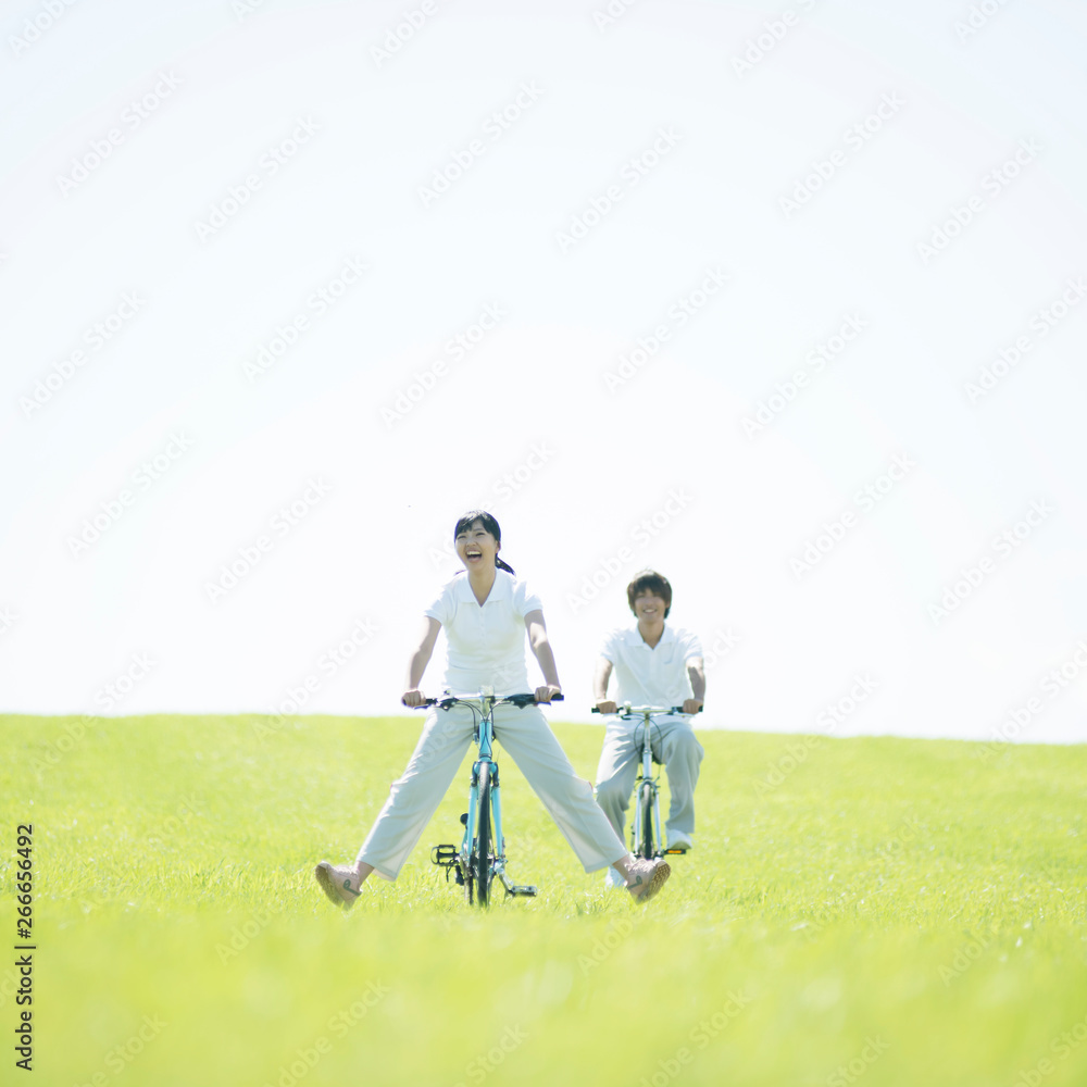 Fototapeta premium 草原で自転車に乗るカップル