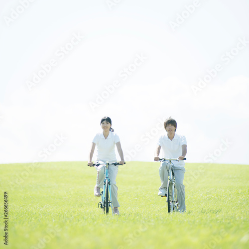 草原で自転車に乗るカップル