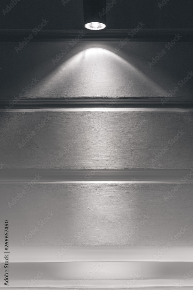 Obraz premium Gray plastered wall with a beam of light from the spotlight.