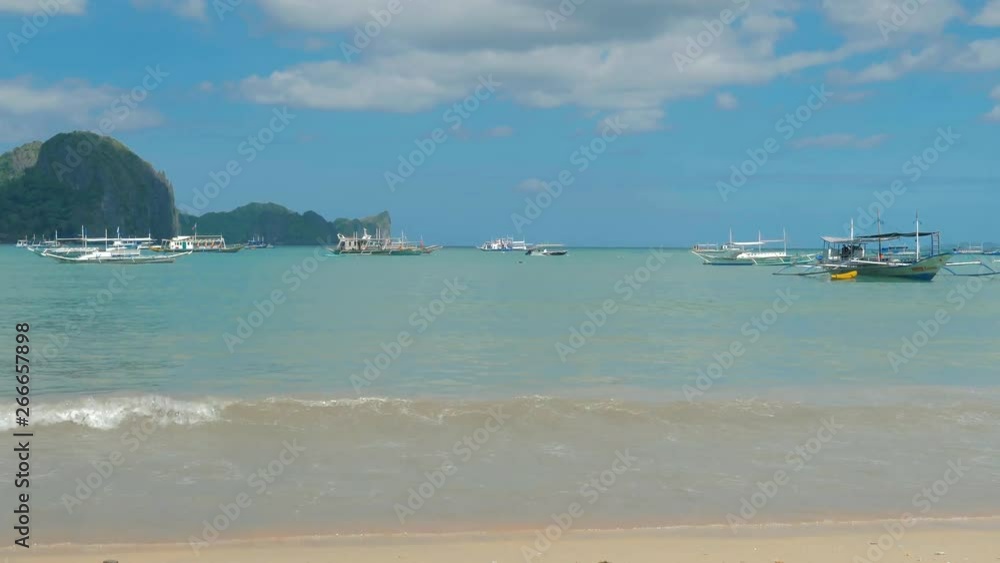 Traditional philippines boats anchored in the bay with clear and turquoise water on sunny day. Boats in the tropical lagoon. Tropical landscape. El Nido, Palawan island, Philippines. Traditional philippines boats anchored in the bay with clear and turquoise water on sunny day. Boats in the tropical lagoon. Tropical landscape. El Nido, Palawan island, Philippines.