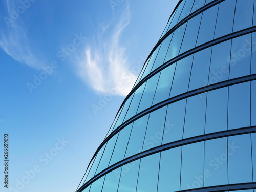 Photography 3D stimulate of high rise curve glass building and dark steel window system on blue sky background,Business concept of future architecture,lookup to the angle of the building