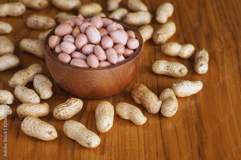 Peanut in wooden bowl on classic wooden table background, peanut butter Peanut in wooden bowl on classic wooden table background, peanut butter