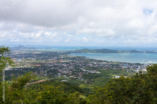 Phuket city scape from high hill ground, can see both town and the beach with cloudy sky © TeeRaiden